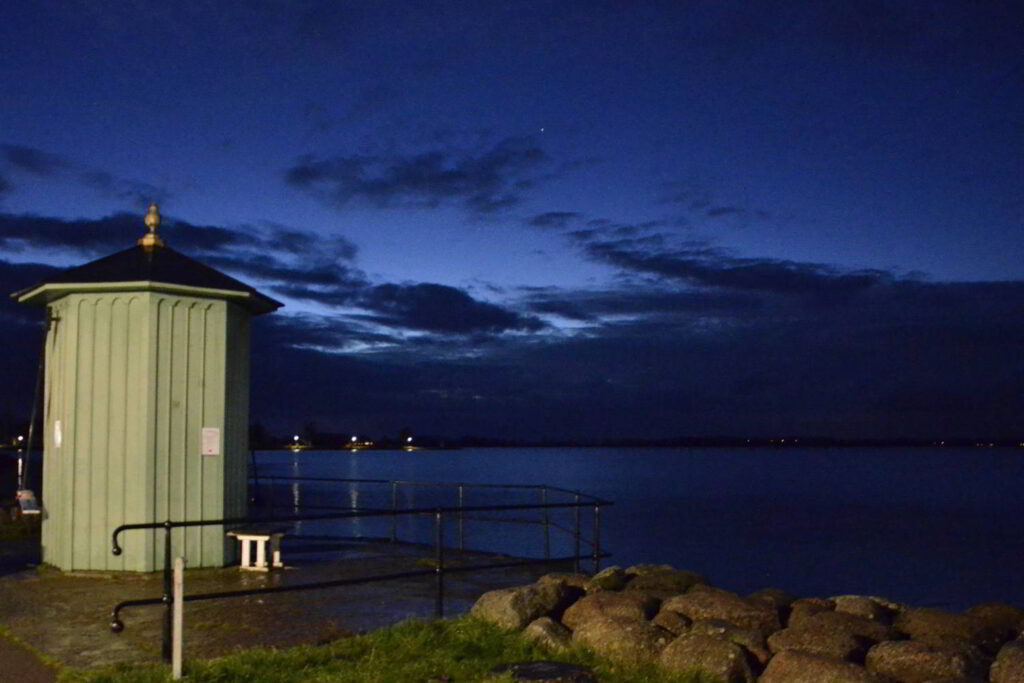 Vättern och klimatförändringarna. Skymningsbild på Pumphuset i Vadstena, vid Vätterns strand.  