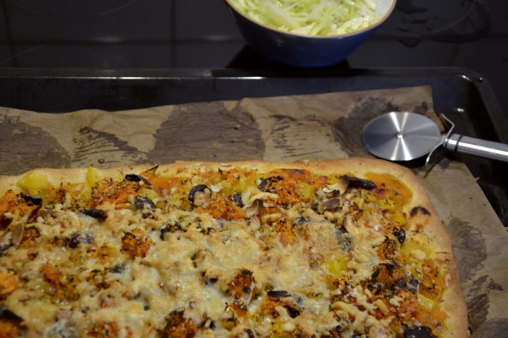 Billig och festlig meny: hemmagjord pizza. Bild på nygräddad pizza.
